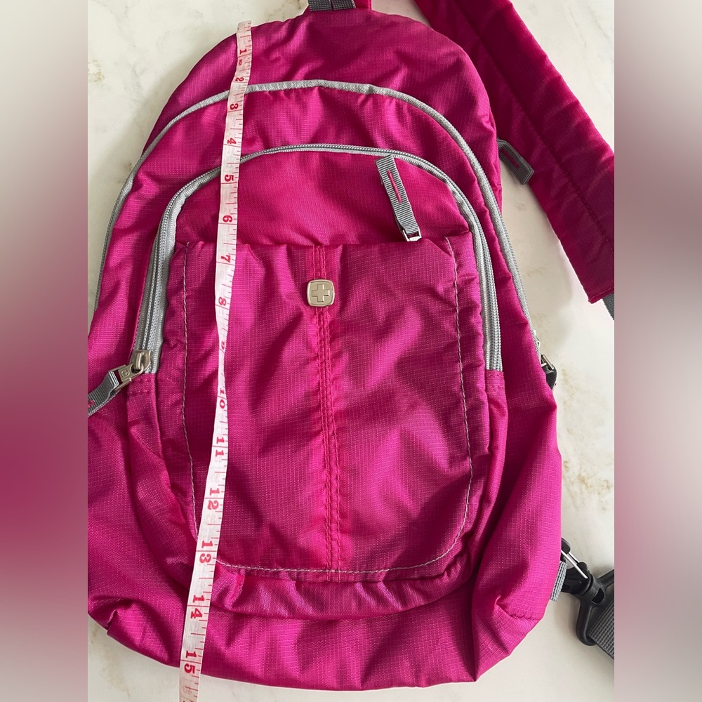 Pink Swiss gear sling Backpack with Gray Accents.